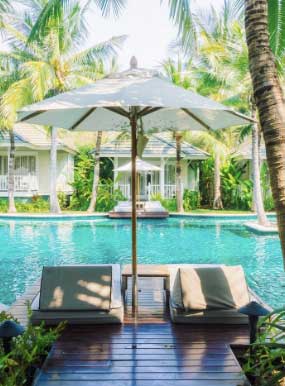 a pool with a deck chair and umbrella