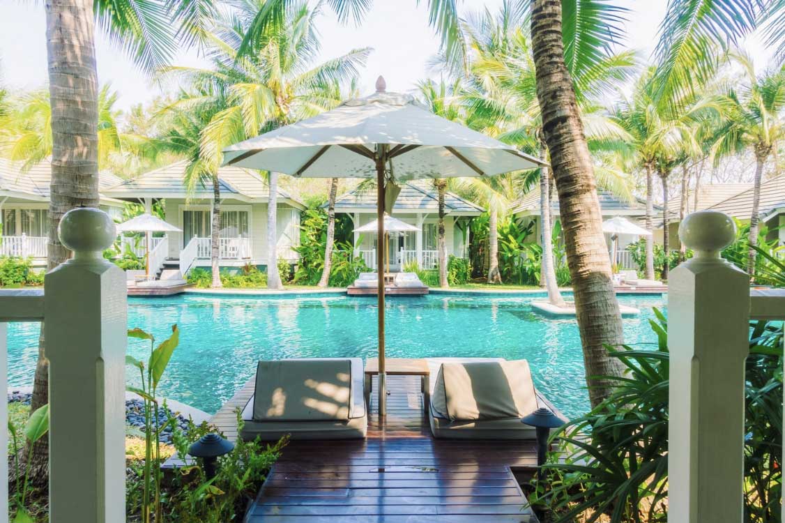 a pool with a deck chair and umbrella