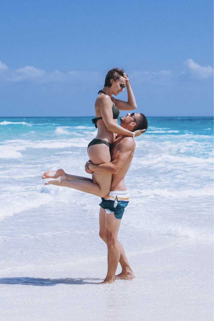 a man holding a woman on a beach