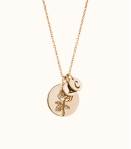 a gold necklace with a flower and a disc