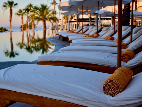 a pool with lounge chairs and umbrellas