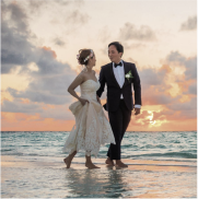 a man and woman in wedding attire on a beach