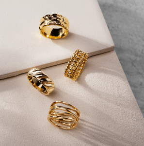 a group of gold rings on a white surface