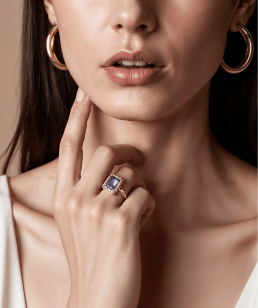 a woman wearing a ring and earrings