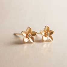 a pair of gold earrings with flowers