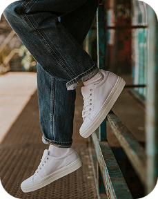 a person's legs and feet in white shoes