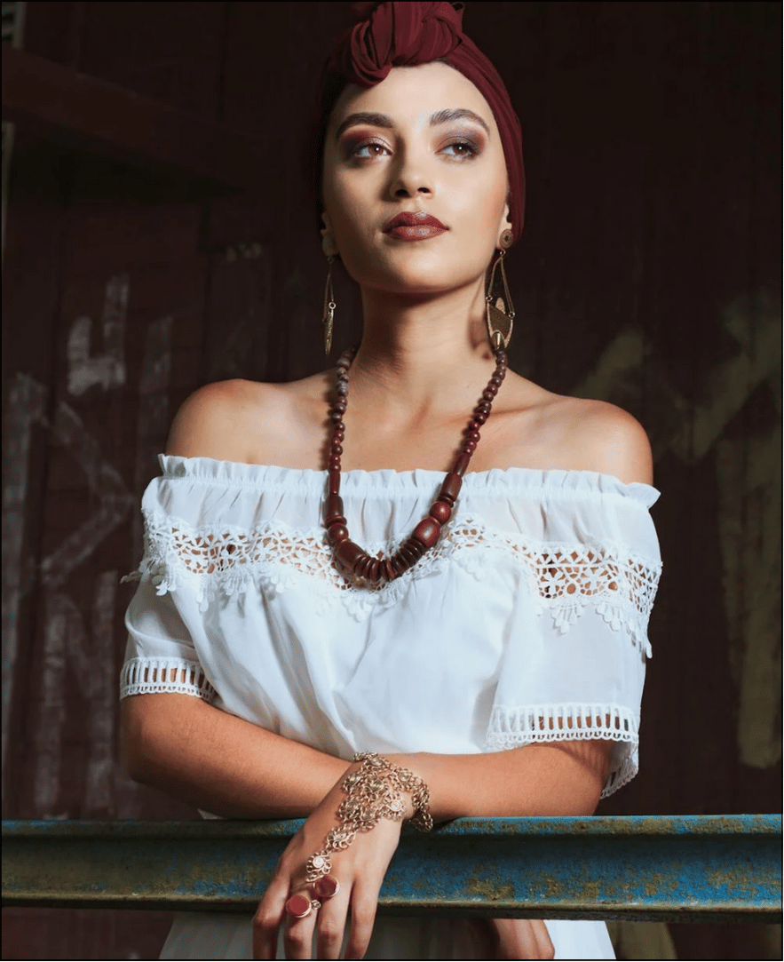 a woman with a red headband and necklace