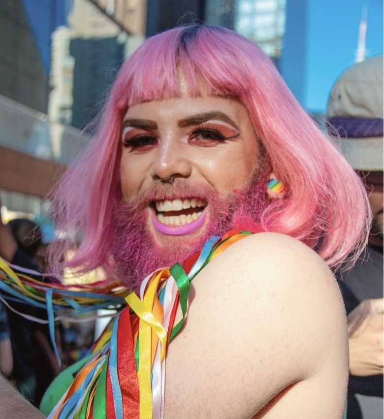 a man with pink hair and beard smiling