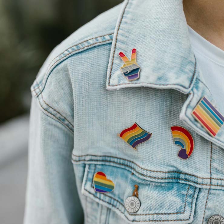 a person wearing a denim jacket with pins