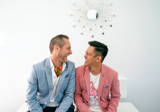 two men sitting on a table laughing