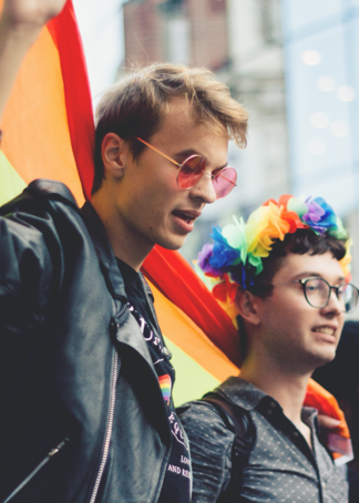 a man wearing glasses and a rainbow headband