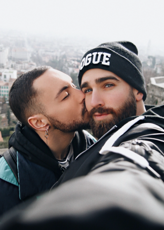 a man kissing another man's cheek