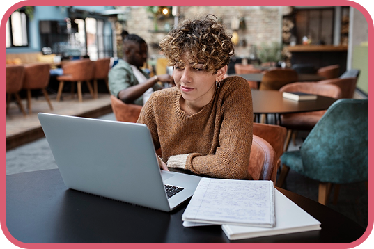 a woman sitting at a table with a laptop