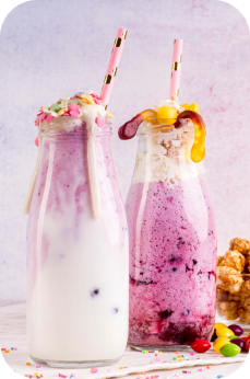 two milkshakes with straws and candy
