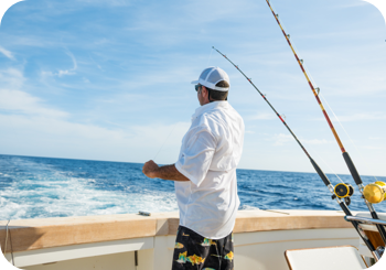a man standing on a boat with fishing poles