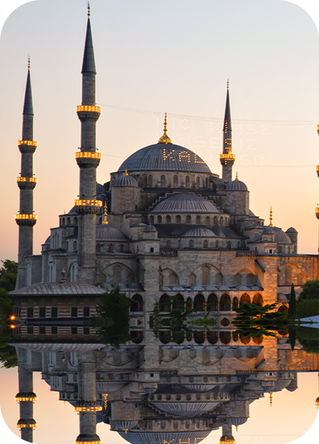 a large building with towers and a body of water