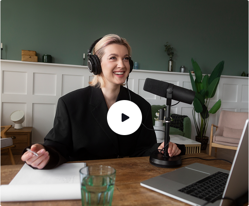 a woman wearing headphones and sitting at a desk with a microphone