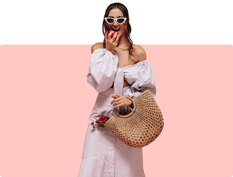 a woman holding a straw bag and eating an apple