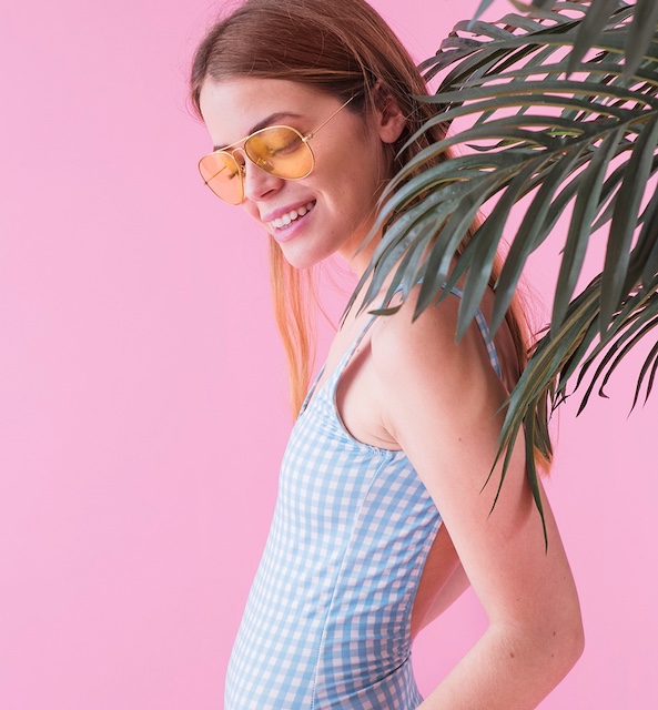 a woman in a blue and white checkered swimsuit and sunglasses