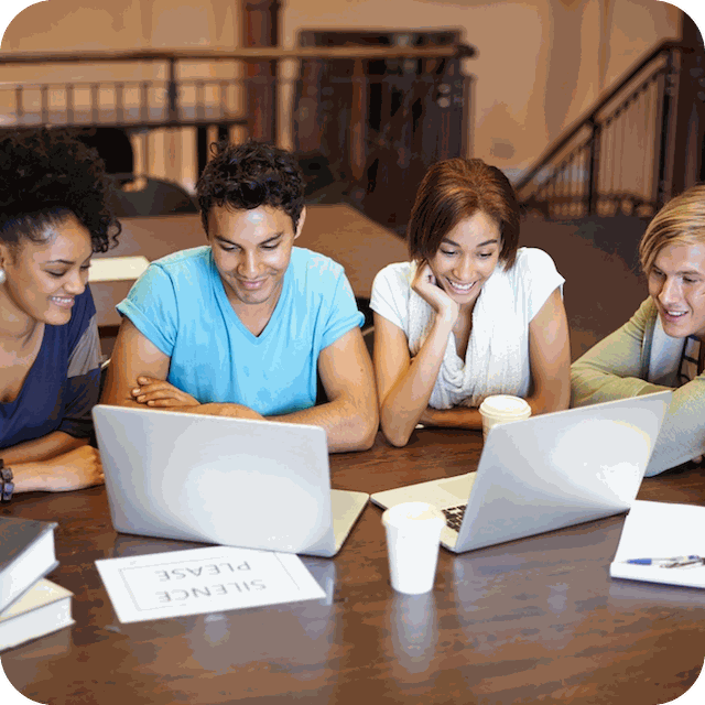 a group of people looking at a laptop