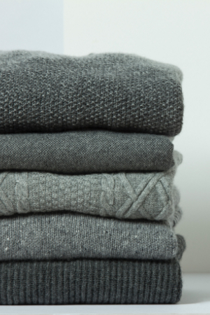 Pile of dark grey sweaters 