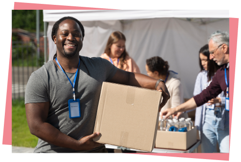 Man Holding Box In Front Of Volunteering Stand Photo
