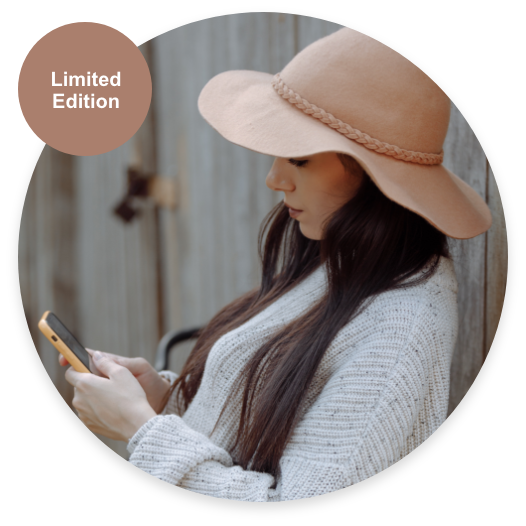 Brunette girl with a beige felt hat holding her cellphone