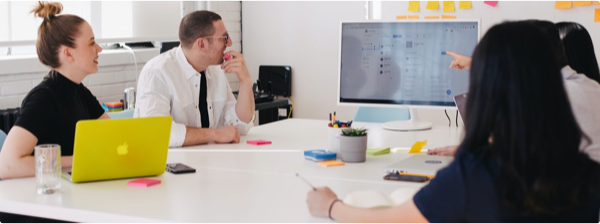 Team looking at computer in a meeting
