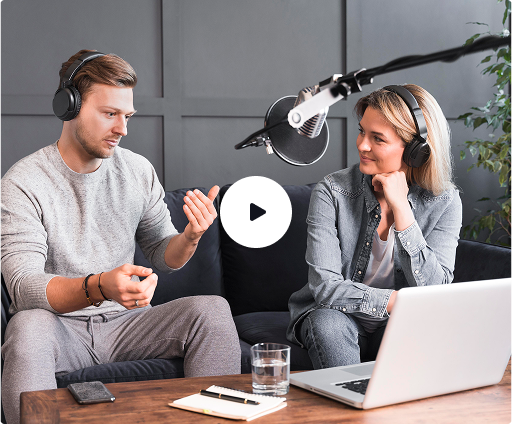 a man and woman sitting on a couch with a laptop and headphones