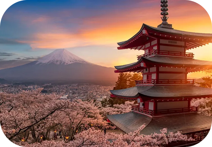 a pagoda with cherry blossoms in front of a mountain