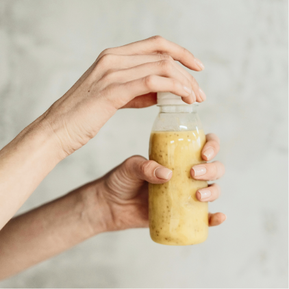 a person holding a bottle of smoothie