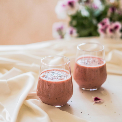two glasses of pink liquid on a white cloth