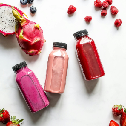 a group of bottles of juice and fruits