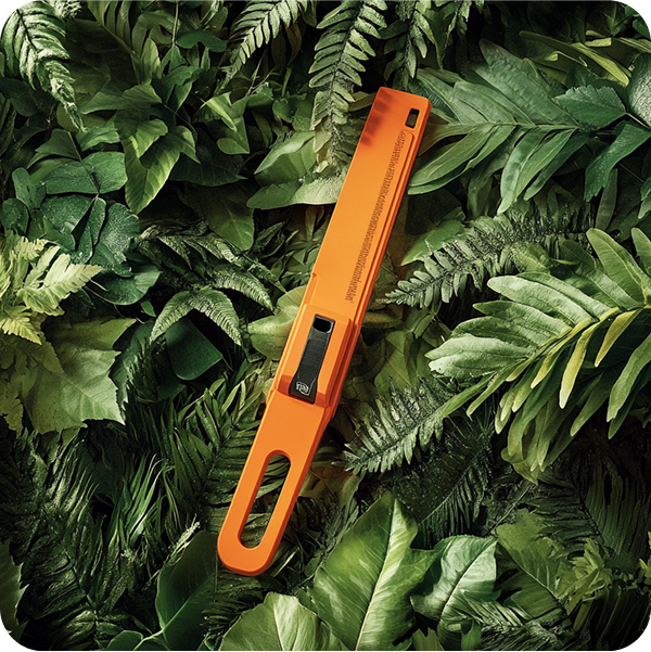 a orange tool lying on a green plant