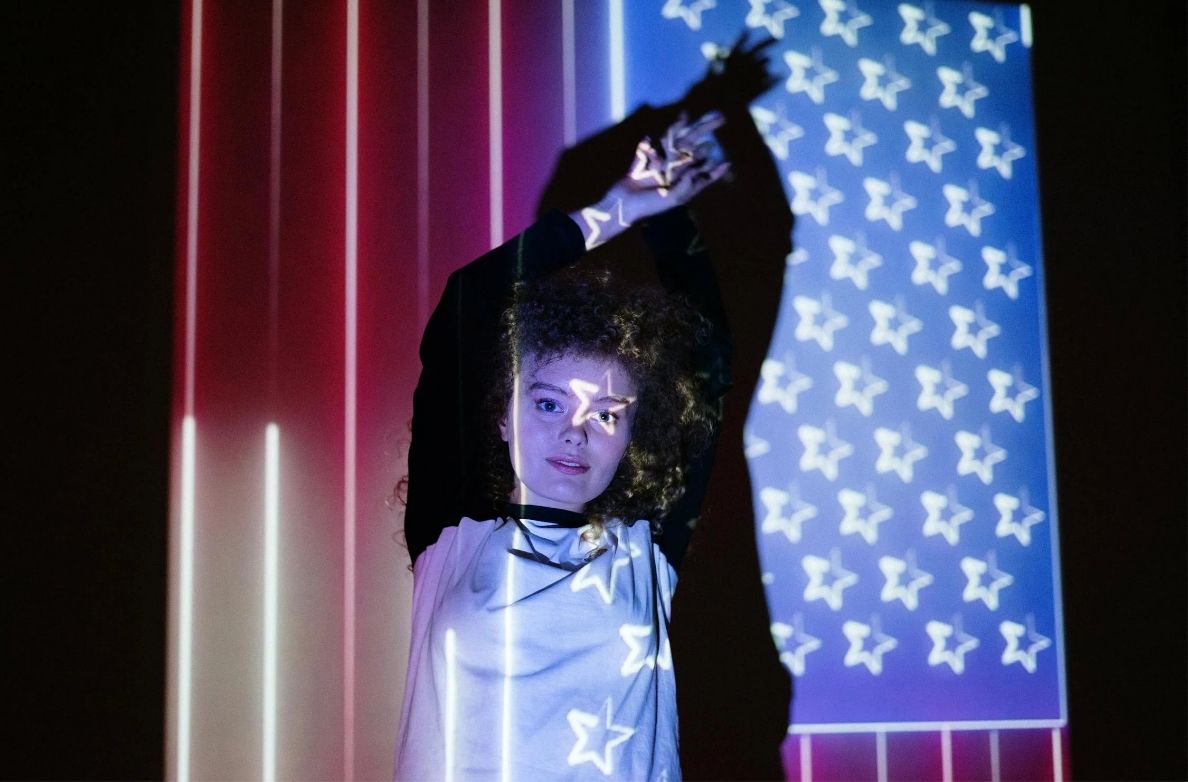 a woman with curly hair and a projector