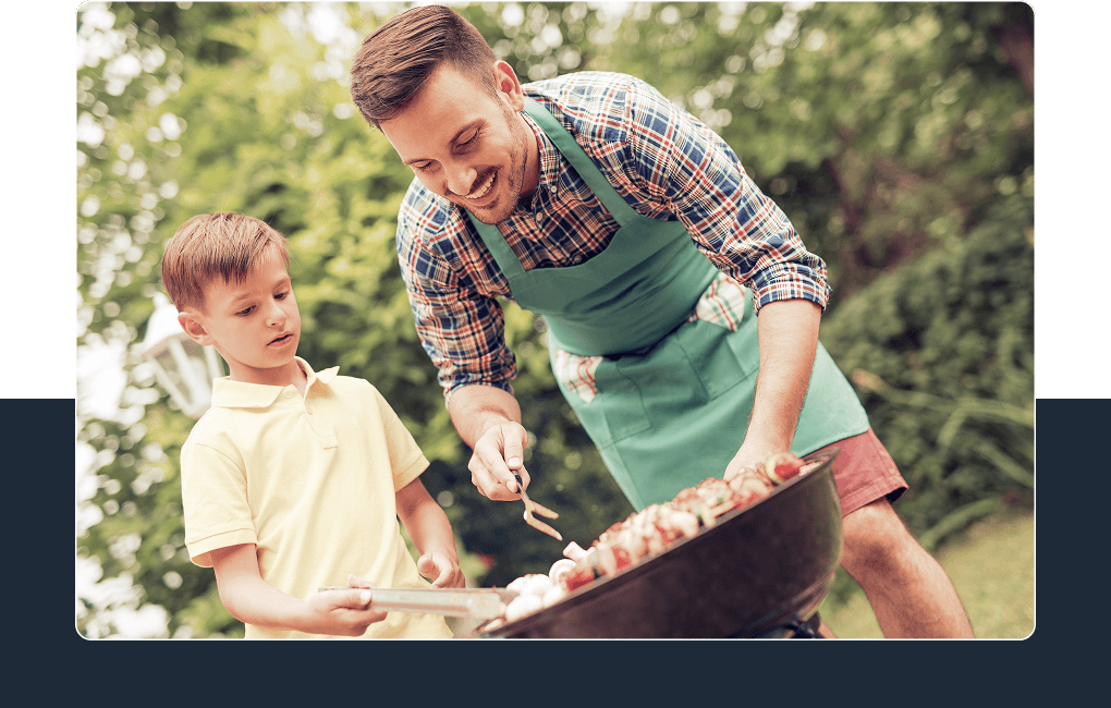 father and son cooking food on a grill