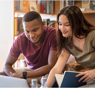 a man and woman looking at a laptop