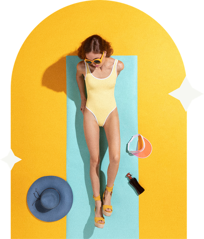 a woman lying on a mat with sunglasses and a hat