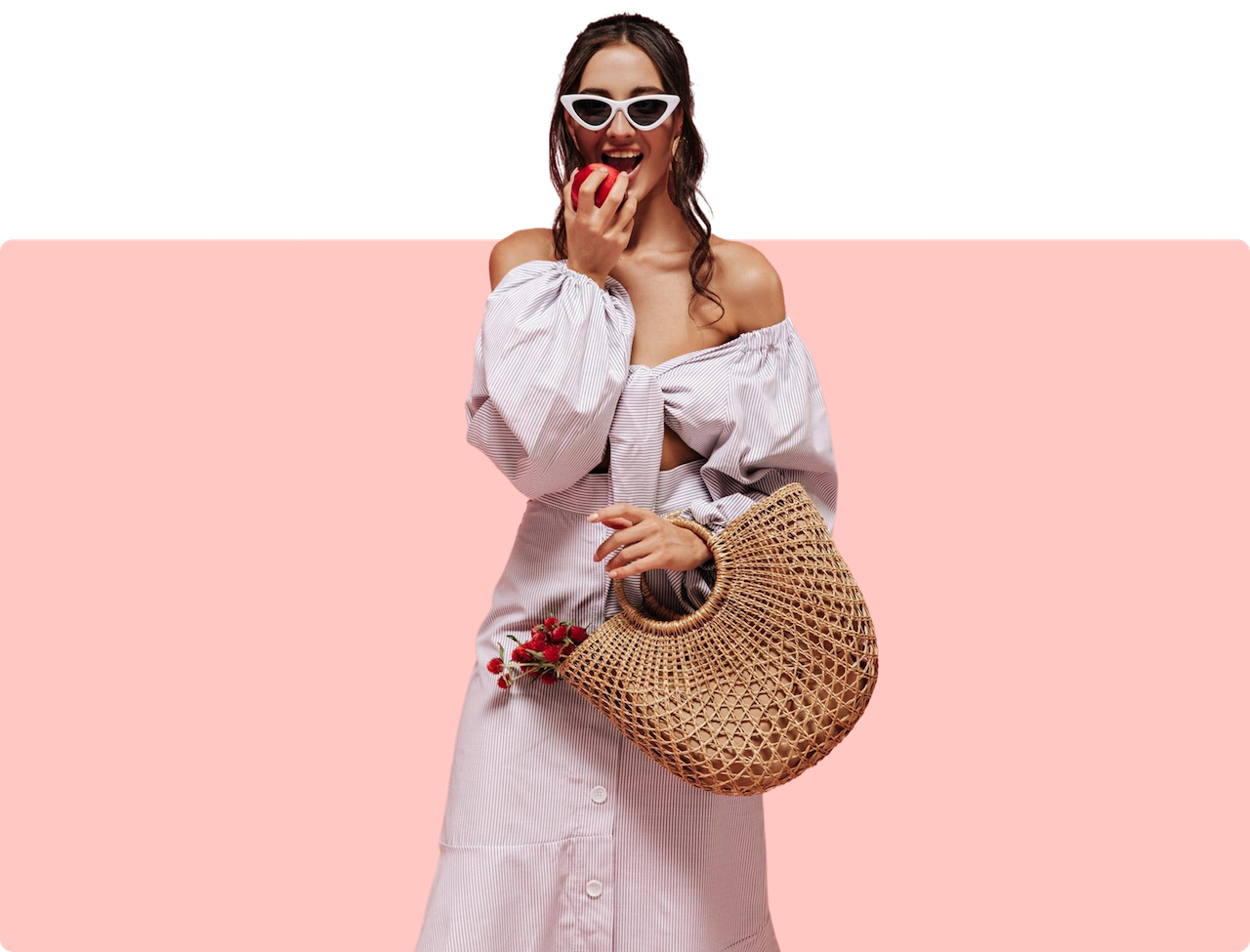 a woman holding a straw bag and eating an apple
