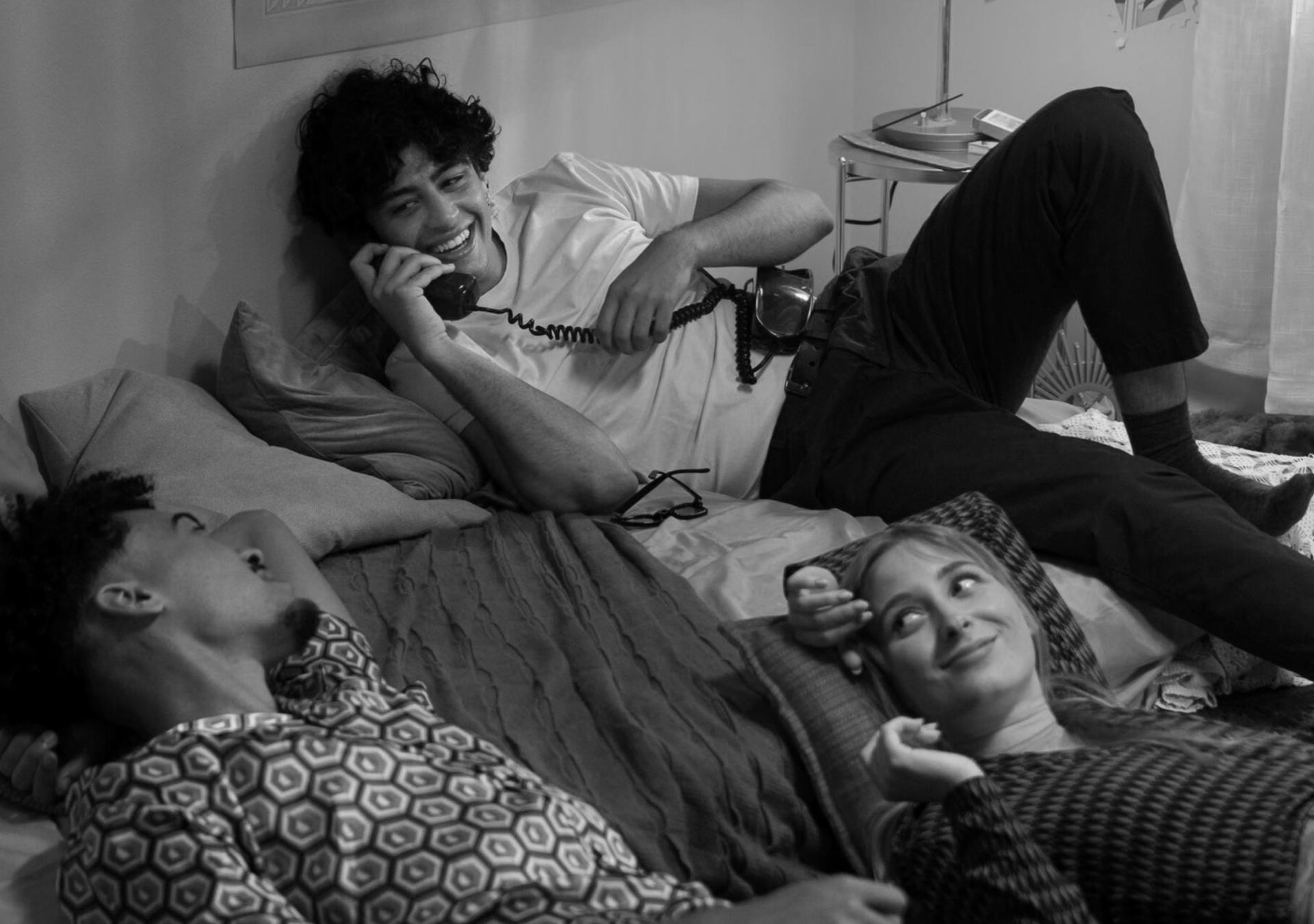 a man on the phone and a woman lying on the bed