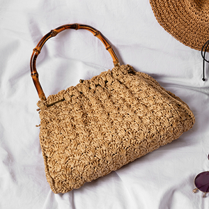 a straw bag and sunglasses on a white sheet
